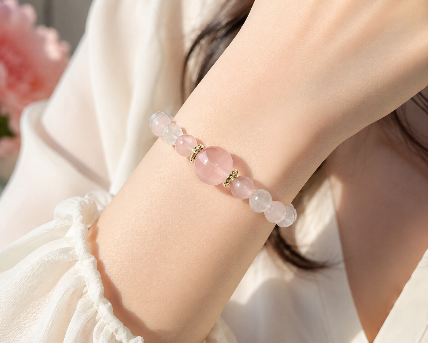 กำไลหินโรสควอตซ์ธรรมชาติเม็ดกลมสีชมพูอ่อนบนพื้นหลังสีดำ